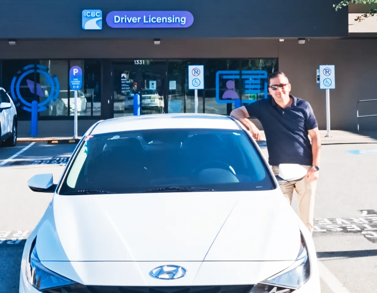 Zula instructor beside the lesson car outside the ICBC Driver Licensing office in North Vancouver